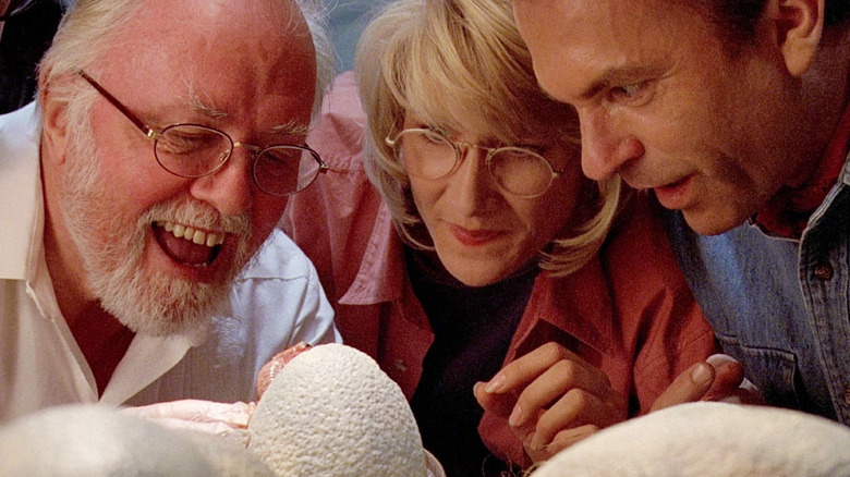 John Hammond, Ellie Sattler, and Alan Grant watching a raptor hatch in Jurassic Park