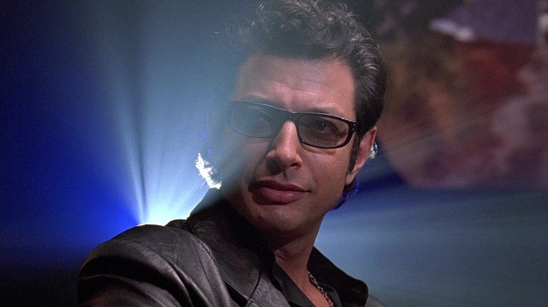 Jeff Goldblum as Ian Malcolm sitting at a lunch table in Jurassic Park