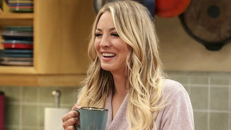 Penny laughing and holding a coffee cup on The Big Bang Theory