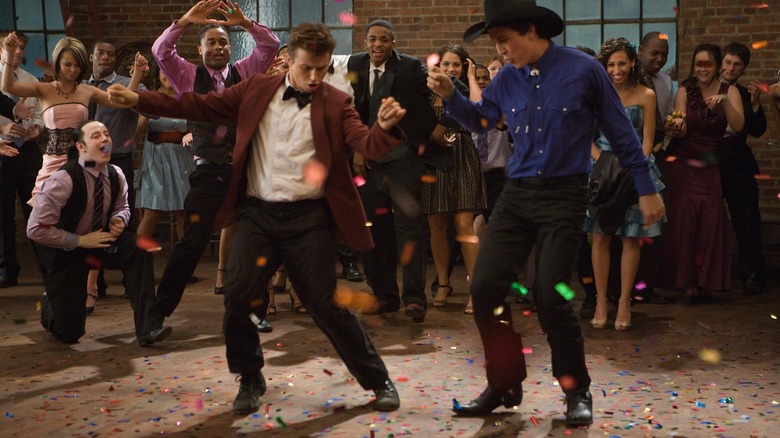 Two guys dancing at a party with a happy crowd behind them in Footloose (2011)
