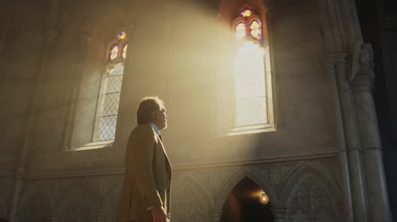 Benoit Blanc, badend in het zonlicht dat door een kerkraam naar binnen stroomt, in Wake Up Dead Man