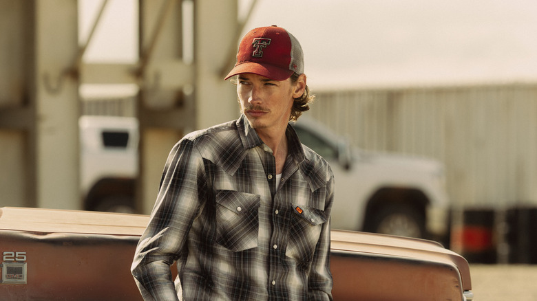 Jacob Lofland's Cooper Norris stands against a truck by an oil rig in Landman