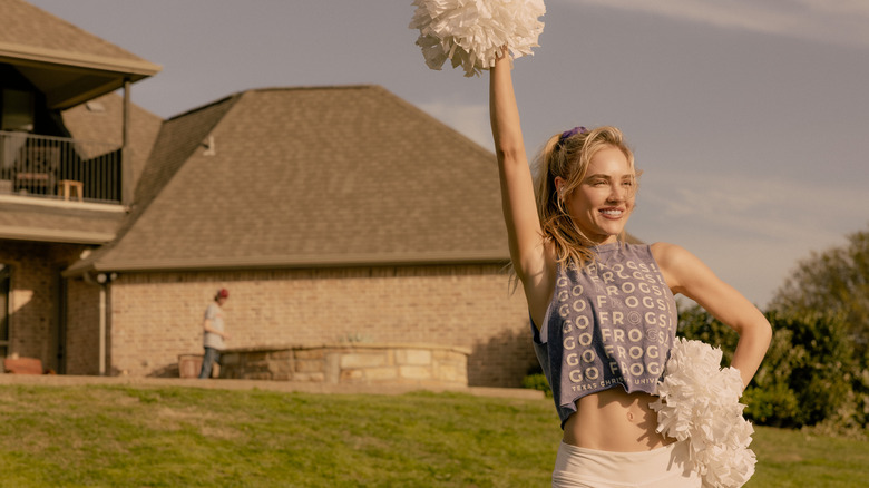 Michelle Randolph's Ainsley Norris smiles as holds up her pom-poms while standing in her back yard in Landman