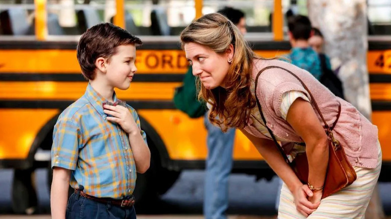 Mary leaning down to smile at Young Sheldon in front of a school bus on Young Sheldon