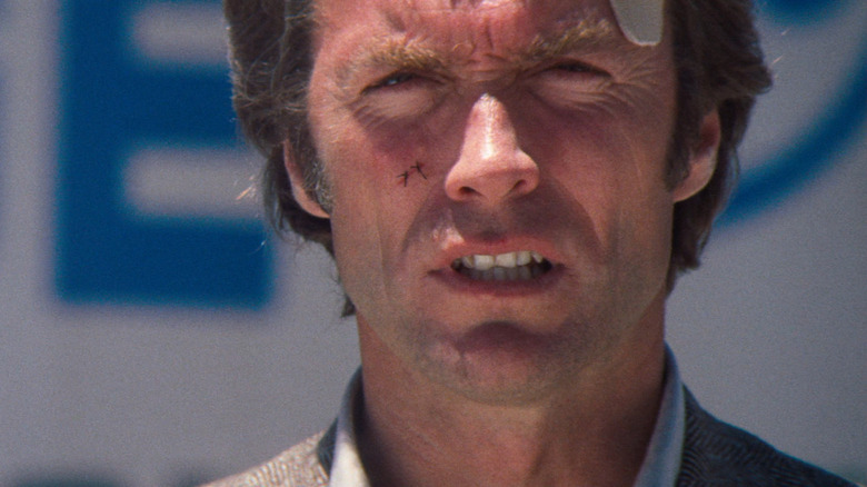 Clint Eastwood as Harry Calahan squints with a bandage on his temple in Magnum Force