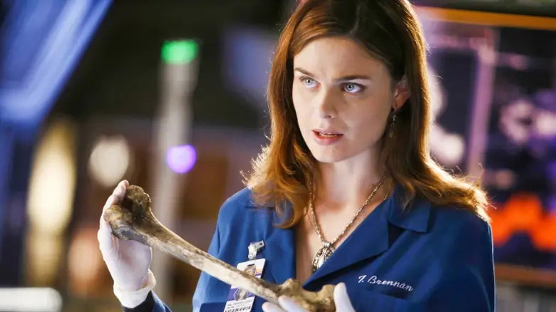 Temperance Brennan segurando um osso humano em Bones