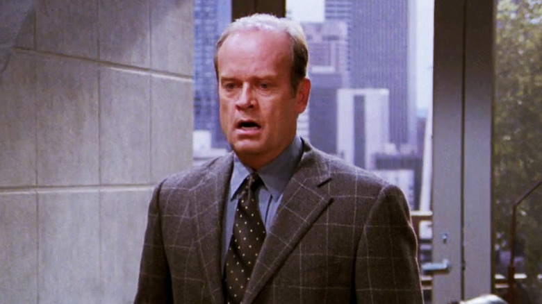 Kelsey Grammer's Frasier Crane stands in his apartment looking shocked in Frasier