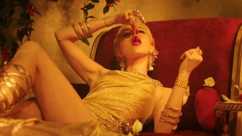 Aubrey Plaza as Wow Platinum eating fruit on a red chair in Megalopolis