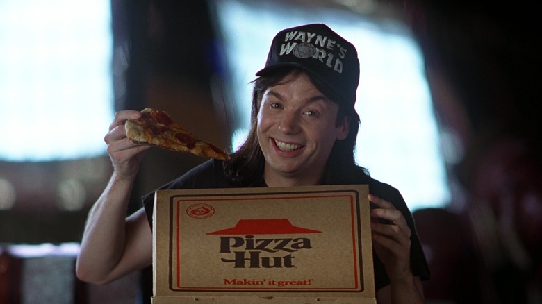 Wayne enjoying a slice of pizza from a well-known pizza establishment in Wayne's World