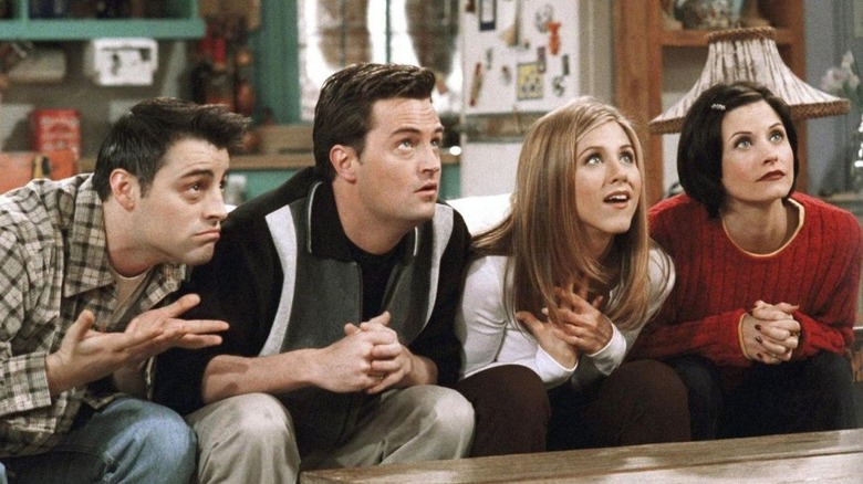 Matthew Perry's Chandler Bing and others are sitting and looking up expectantly on Friends
