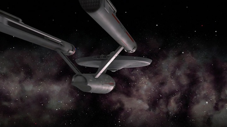 The U.S.S. Enterprise flying away into the stars on Star Trek.