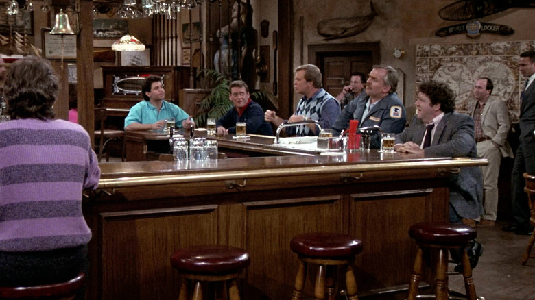 A group of people sitting along the bar, a scene from Cheers.