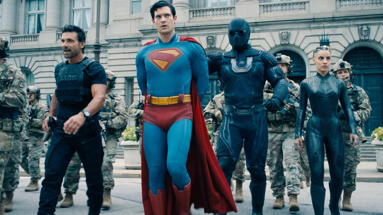 David Corenswet as Superman led away in handcuffs by Frank Grillo as Rick Flag, Sr., María Gabriela de Faría as the Engineer, and David Corenswet as Ultraman in Superman