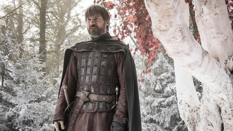 Khayi stands in front of a tree and rises on the game of thrones