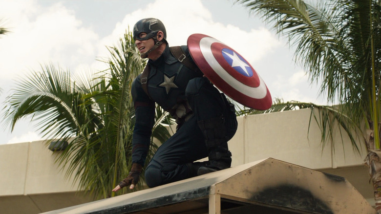 Captain America, in full suit, squatting on a van in the captain of America: a civil war.