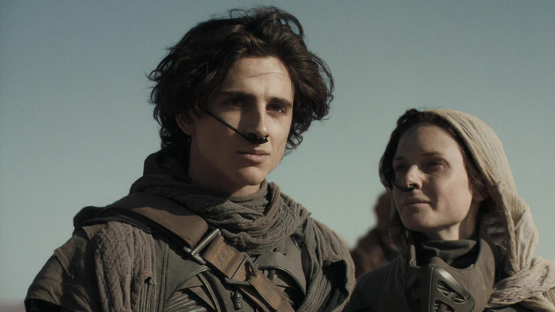 Paul and Lady Jessica standing in the desert in Dune (2021)