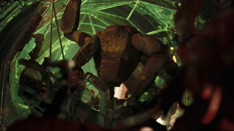 James Ortiz as the voice of Rocky standing up with an arm raised in his containment sphere in Project Hail Mary