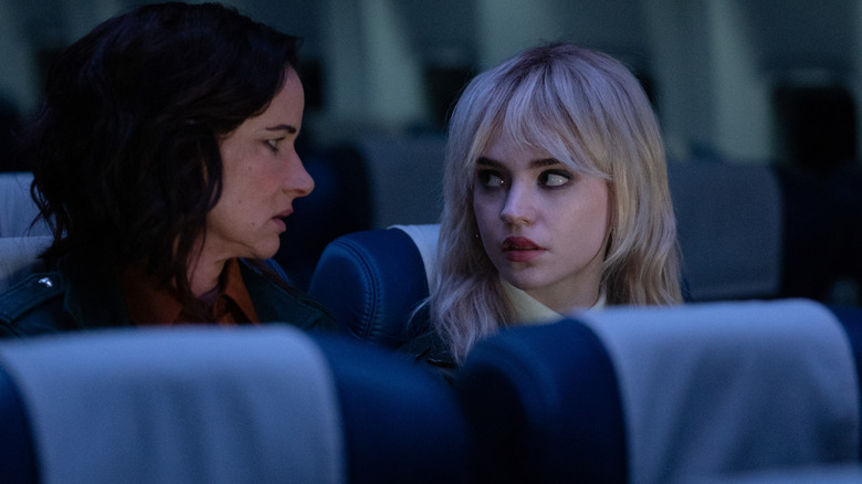 Adult Natalie and Teen Natalie on a plane looking at each other on Yellowjackets