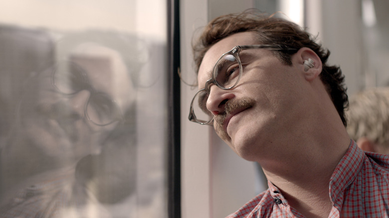 Joaquin Phoenix leans his head against a window in Her