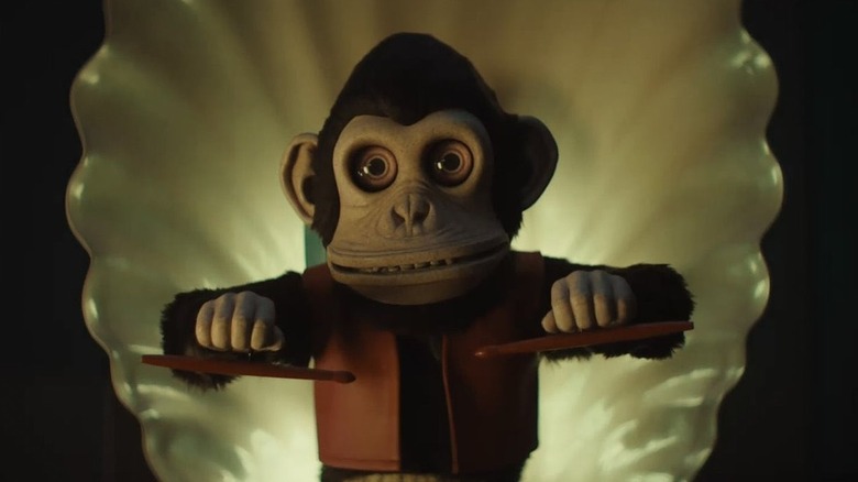 A scary monkey toy holding pestles in the monkey
