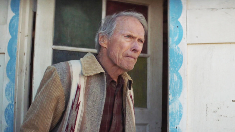 Clint Eastwood's Mike Milo stands in a doorway looking off into the distance in Cry Macho