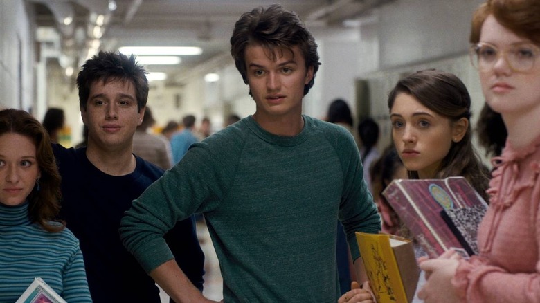 Steve, Nancy, and Barb stand in the school hallway in Stranger Things.