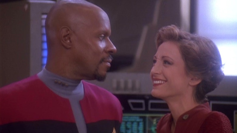 Avery Brooks as Benjamin Sisko looking at Nana Visitor as Kira Nerys as she laughs in Deep Space Nine