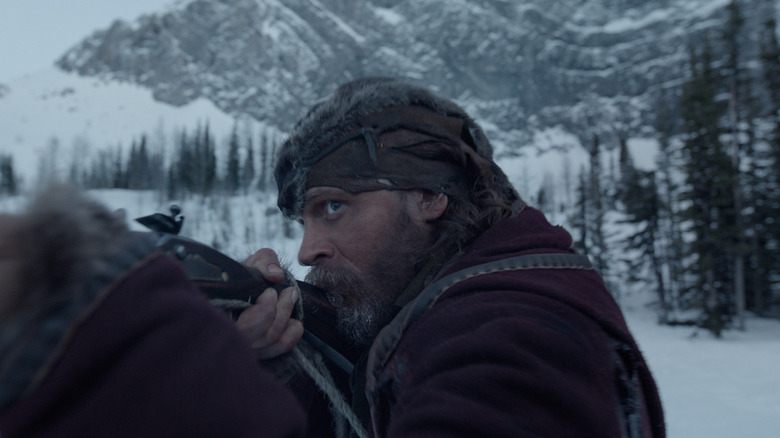 Tom Hardy as John S. Fitzgerald aiming a rifle in The Revenant