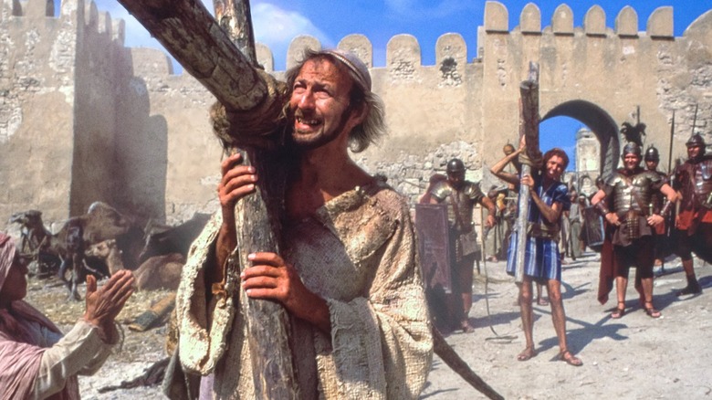 Brian carrying cross in crowd