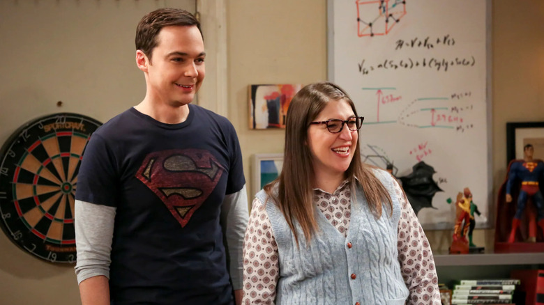 Sheldon and Amy smiling in the living room on The Big Bang Theory