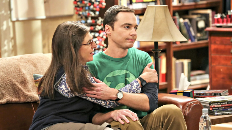 Amy and Sheldon hugging on the couch in The Big Bang Theory