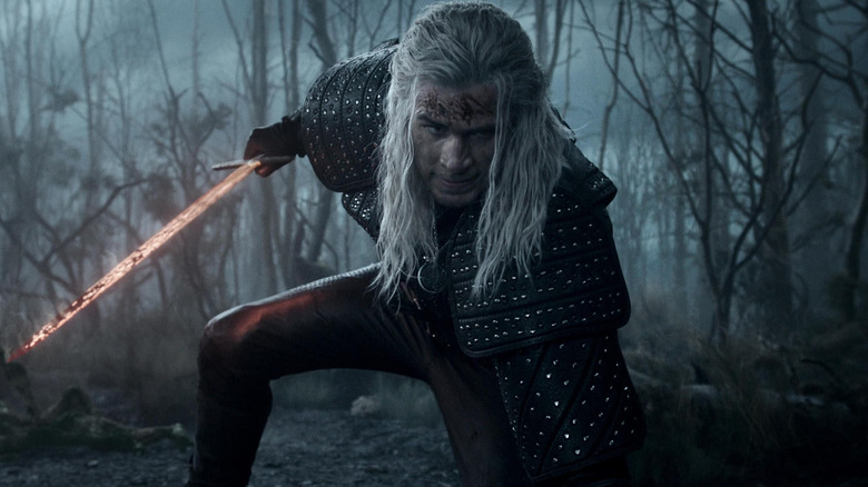 Liam Hemsworth as Geralt kneeling with his sword in The Witcher
