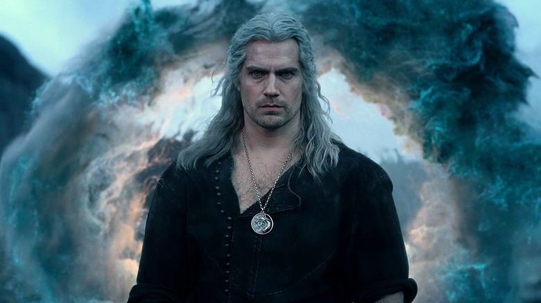 Henry Cavilll as Geralt standing in front of a smoke portal in The Witcher