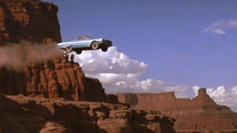 Blue car flying off cliff