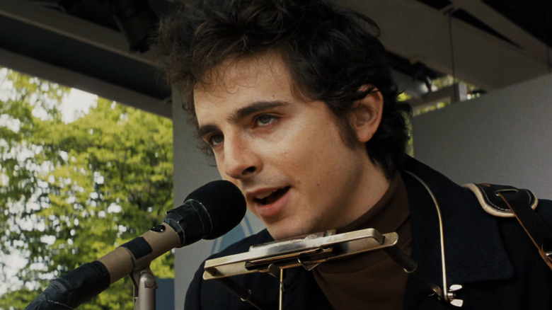 Timothée Chalamet's Bob Dylan sings into a microphone in A Complete Unknown