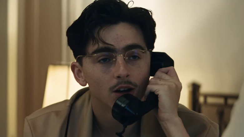 Timothée Chalamet's Marty Mauser talks on the phone in Marty Supreme