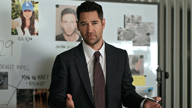 Manuel Garcia-Rulfo as Mickey Haller in front of an evidence board in The Lincoln Lawyer