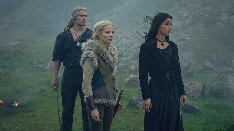 Geralt (Henry Cavill), Ciri (Freya Allan), and Yennefer (Anya Chalotra) stand together in a misty valley in The Witcher