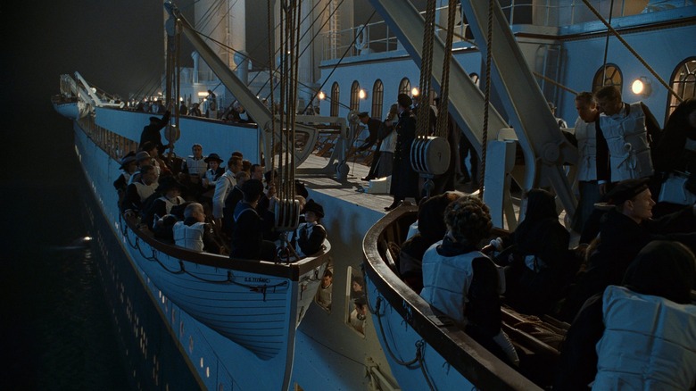 Several passengers wearing lifejackets boarding lifeboats in Titanic