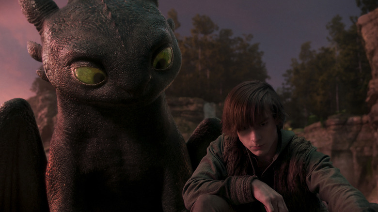 Toothless watches over Hiccup's shoulder with curiosity in How to Train Your Dragon