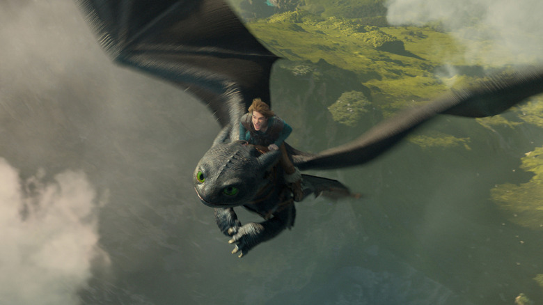 Mason Thames as Hiccup riding atop the dragon Toothless in How To Train Your Dragon