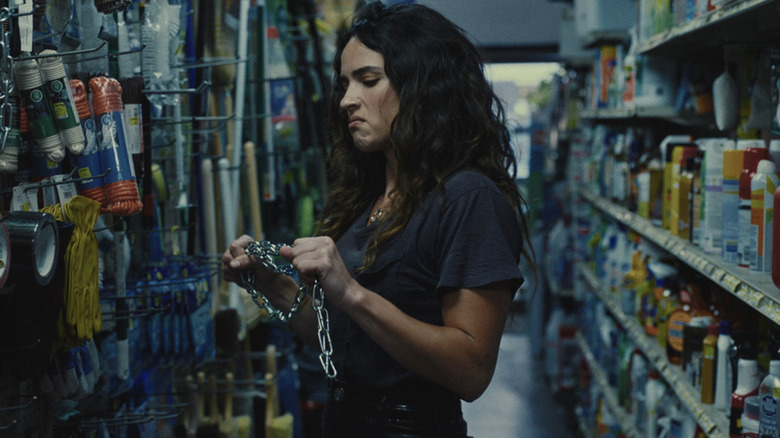 Adria Arjona's Celeste Cross holds a chain in a hardware store in Onslaught