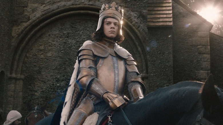 Woody Norman as Richard II of England wearing armor while riding a horse in The Uprising