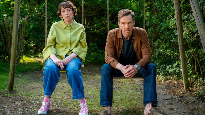Olivia Colman as Ivy Rose and Benedict Cumberbatch as Theo Rose sitting on swings and looking forlorn in The Roses