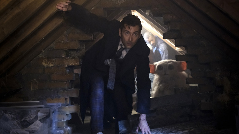 David Tennant's The Doctor, Miriam Margolyes' The Meep, and Karl Collins' Shaun Temple navigating a dark attic on Doctor Who