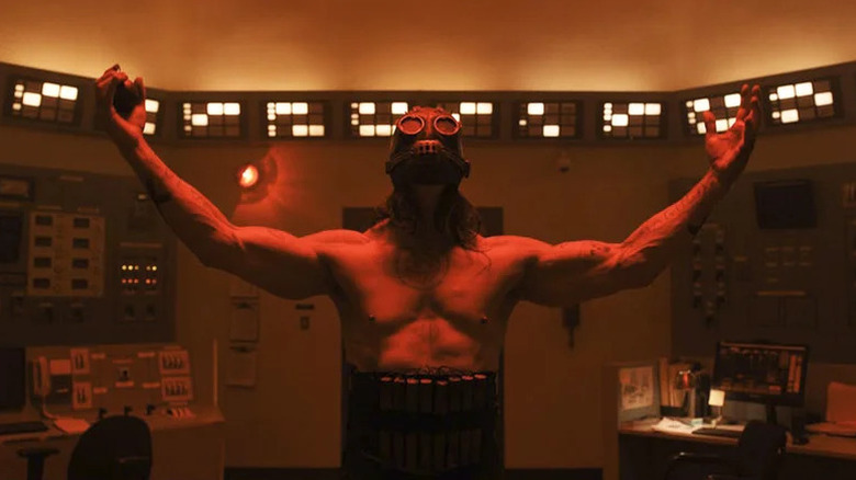 சைக்கோ கில்லரில் உள்ள சக்தி வசதியில் சட்டையின்றி கைகளை உயர்த்திய சாத்தானிக் ஸ்லேஷர்