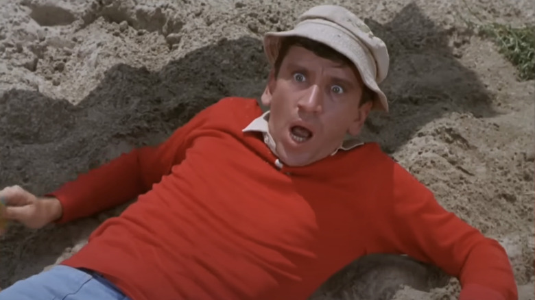 Bob Denver as Gilligan looks shocked as he lays in sand on Gilligan's Island