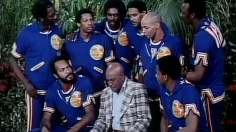 The Harlem Globetrotters gather around Scatman Crothers as their coach in The Harlem Globetrotters on Gilligan's Island