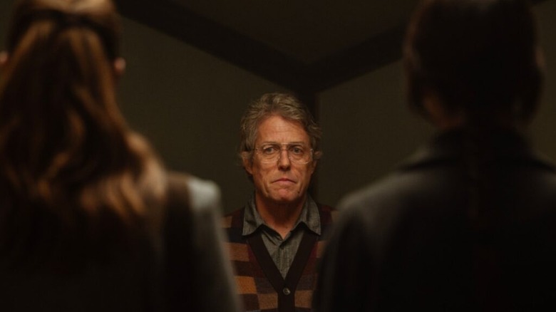 Mr. Reed looking between Sister Barnes and Sister Paxton's shoulders in Heretic
