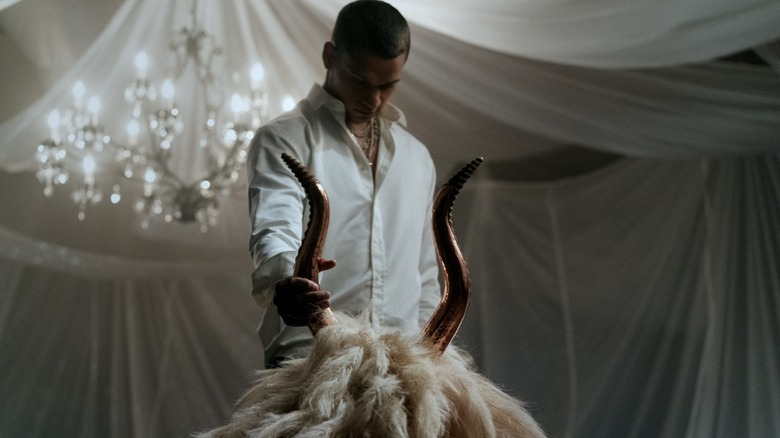 Cam looking down at a creepy goat mask  on a table in Him